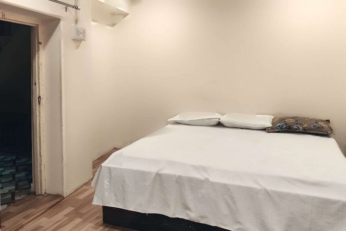 A double bed made up in white in a heritage room